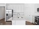 Kitchen island features white countertops, stainless sink, and modern faucet at 7840 Magnolia St, New Palestine, IN 46163