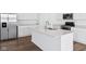Kitchen island features white countertops, stainless sink, and modern faucet at 7840 Magnolia St, New Palestine, IN 46163