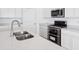 This kitchen features stainless steel appliances, white cabinets and quartz countertop space for food preparation at 7840 Magnolia St, New Palestine, IN 46163