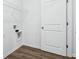 Functional laundry room with vinyl plank flooring, washer/dryer hookups, and a wire shelf at 7840 Magnolia St, New Palestine, IN 46163