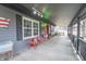 Spacious covered front porch with vintage furniture and decor, offering a cozy outdoor space at 11197 N Gasburg Rd, Mooresville, IN 46158