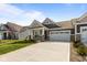 Inviting single-story residence showcasing stone accents, gray siding, a two-car garage, and a spacious driveway at 16892 Cattle Hollow Ln, Noblesville, IN 46060
