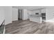 Open-concept kitchen with white cabinets flows into the spacious living area, featuring wood-look floors at 16892 Cattle Hollow Ln, Noblesville, IN 46060