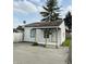 A charming home with a small front porch featuring wooden support beams, a white front door, and a satellite dish at 2342 Hoyt Ave, Indianapolis, IN 46203