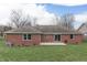 Well-maintained backyard with a spacious lawn, a brick home exterior, and a concrete patio at 4208 E Epler Ave, Indianapolis, IN 46237
