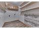 Bright laundry room featuring wood-look vinyl flooring, built-in shelving, wooden cabinets, and washer/dryer hookups at 4208 E Epler Ave, Indianapolis, IN 46237