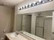 Bathroom featuring dual sinks, large mirror with Hollywood lighting, and a glass shower at 672 Rocky Meadow Dr, Greenwood, IN 46143