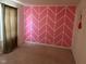 Bedroom with a striking pink and white geometric accent wall and neutral carpeting at 672 Rocky Meadow Dr, Greenwood, IN 46143