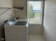 Functional laundry area with a washer, shelving, and natural light from a window at 672 Rocky Meadow Dr, Greenwood, IN 46143