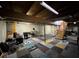 Unfinished basement with exposed ceiling beams, cement block walls, and multi-colored carpet tiles at 954 Camp St, Indianapolis, IN 46202