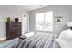 Bright bedroom with large window, dresser, and striped bedding at 9895 Baneberry Ln, Carmel, IN 46290