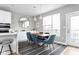 Modern dining area with a wood table, blue velvet chairs, and hardwood floors at 9895 Baneberry Ln, Carmel, IN 46290