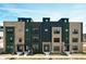 Stylish townhomes boasting brick and modern paneling under a vibrant blue sky with a fresh lawn at 9895 Baneberry Ln, Carmel, IN 46290