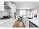 Bright kitchen boasts white cabinets, quartz countertops, and stainless steel appliances at 9895 Baneberry Ln, Carmel, IN 46290