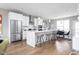 Open concept kitchen with island, stainless steel appliances, and hardwood floors at 9895 Baneberry Ln, Carmel, IN 46290