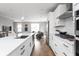 Open concept kitchen with island, stainless steel appliances, and hardwood floors at 9895 Baneberry Ln, Carmel, IN 46290