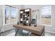 Modern home office with built-in shelving, large desk, and plenty of natural light at 16222 Browning Ct, Fishers, IN 46037