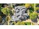 An aerial view showcasing a home with a deck, trampoline, and gray shingled roof surrounded by mature trees at 3441 S Overlook Pass, New Palestine, IN 46163