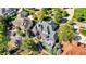 Areal view of a brick home featuring a deck, trampoline, pond, and mature trees in a residential neighborhood at 3441 S Overlook Pass, New Palestine, IN 46163