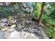 Secluded backyard seating area with a decorative bench nestled among rocks and greenery at 3441 S Overlook Pass, New Palestine, IN 46163