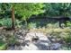 Tranquil creek setting with a rustic bench, surrounded by mature trees and natural stones at 3441 S Overlook Pass, New Palestine, IN 46163