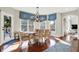 Bright dining room features hardwood floors, a chandelier, and large windows with an adjacent deck at 3441 S Overlook Pass, New Palestine, IN 46163