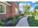 Landscaped walkway leads to a traditional brick home with well-maintained gardens and trimmed hedges at 3441 S Overlook Pass, New Palestine, IN 46163