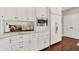 Bright kitchen features white cabinets, marble countertops, stainless steel microwave, and wooden floors at 3441 S Overlook Pass, New Palestine, IN 46163