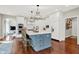 Well-lit kitchen with a large island featuring a blue base, white cabinets, and modern appliances for culinary enthusiasts at 3441 S Overlook Pass, New Palestine, IN 46163