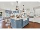 Spacious kitchen with white cabinets, a blue island, a farmhouse sink, and views of the breakfast nook at 3441 S Overlook Pass, New Palestine, IN 46163