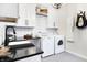 Clean laundry area features a deep sink, countertop space, and a modern white washer and dryer at 3441 S Overlook Pass, New Palestine, IN 46163