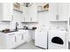 Well-lit laundry room featuring white cabinets, black countertops, and modern washer and dryer at 3441 S Overlook Pass, New Palestine, IN 46163