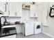 Beautiful laundry room with white cabinets, black counters, and modern appliances at 3441 S Overlook Pass, New Palestine, IN 46163