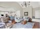 Bright living room with hardwood floors, a kitchen view, and comfortable seating near a window nook at 3441 S Overlook Pass, New Palestine, IN 46163