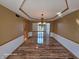 Elegant dining room with hardwood floors, decorative ceiling trim, and a stylish chandelier at 8429 Admirals Cv, Indianapolis, IN 46236