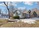 Gray house with stone accents, three-car garage, and a snowy yard at 9706 N Glen Dr, Mooresville, IN 46158