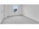 This bedroom features neutral carpeting, white walls, and a view of the backyard at 1082 Stubble Run, Danville, IN 46122