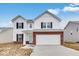 Two-story home featuring white siding, red brick accents, and a two-car garage at 1082 Stubble Run, Danville, IN 46122