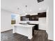 Stylish kitchen boasting an island, dark cabinets, white countertop, and stainless steel appliances at 1082 Stubble Run, Danville, IN 46122