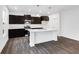 Contemporary kitchen with a white island, dark cabinetry, and modern appliances at 1082 Stubble Run, Danville, IN 46122