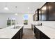 Bright, modern kitchen featuring a white island, dark cabinets, and stainless steel appliances at 1082 Stubble Run, Danville, IN 46122
