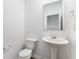 A powder room featuring a pedestal sink, modern fixtures, a mirror, and a commode at 1082 Stubble Run, Danville, IN 46122