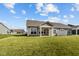 Large backyard with a covered patio and well-kept lawn on a sunny day at 16689 Cattle Hollow Ln, Noblesville, IN 46060