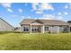 Open backyard featuring a covered patio and lush lawn with homes in a neighborhood setting at 16689 Cattle Hollow Ln, Noblesville, IN 46060