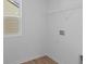 Bright laundry room with a window and white walls, a white wire rack and wood-look vinyl flooring at 1837 James Pierce Dr, Shelbyville, IN 46176