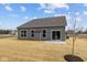 Back view of a single-story home with siding, multiple windows, a sliding door, and a small concrete patio at 5006 Carmine St, Brownsburg, IN 46112