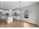 Well-lit kitchen featuring white cabinetry, a central island with a sink, and modern fixtures, offering style at 5006 Carmine St, Brownsburg, IN 46112