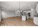 Spacious living area with an open floor plan, showcasing hardwood floors, a kitchen island, and abundant natural light at 5006 Carmine St, Brownsburg, IN 46112