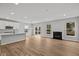 Open-concept living room features wood floors, a fireplace, large windows, and seamless transition to the kitchen at 5006 Carmine St, Brownsburg, IN 46112