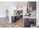 An open kitchen with dark cabinets, stainless steel appliances, and an island with marble countertops at 5677 Starla Ln, Plainfield, IN 46168